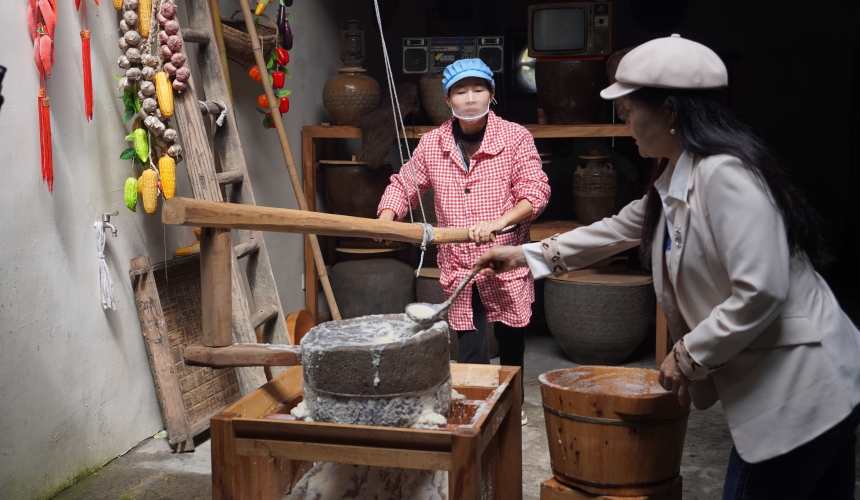 在通山石门村长夏畈古民居群，村民正在手工磨豆，吸引游客前来体验。人民网记者 周雯摄
