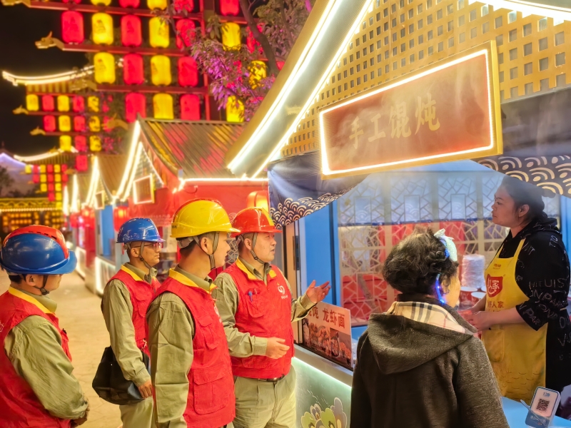国网武汉供电公司“鄂电红马甲”服务队向景区经营人员讲解安全用电知识。