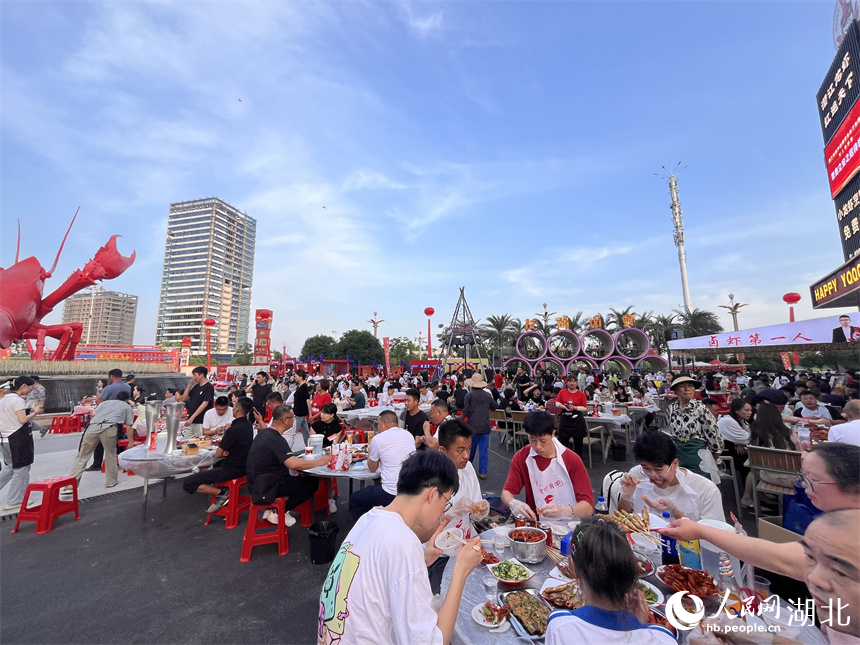 三五成群的食客手口並用，大快朵頤，品嘗著一盤盤色澤飽滿、醇香味美的小龍蝦。人民網記者 張雋攝