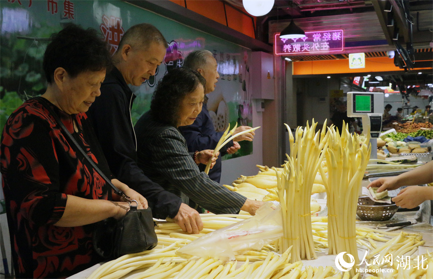 5月30日上午，武汉市民在洪山广场地铁站菜市场买时令蔬菜藕带。人民网记者 周恬摄
