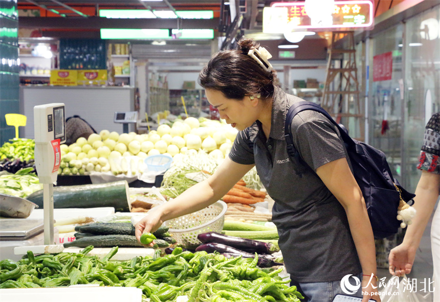 武汉市民下班后在地铁菜市场挑选蔬菜。人民网记者 周恬摄