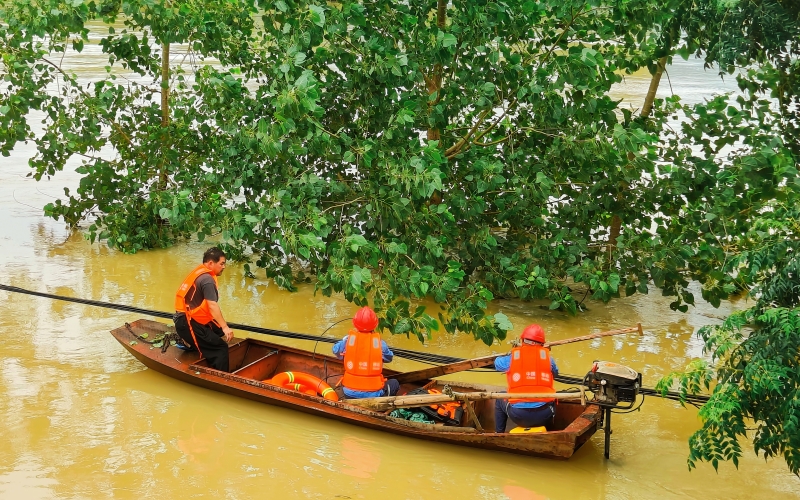 大雨过后，河水暴涨，防汛通信保障队员在浑浊的河水中奋力抢修。