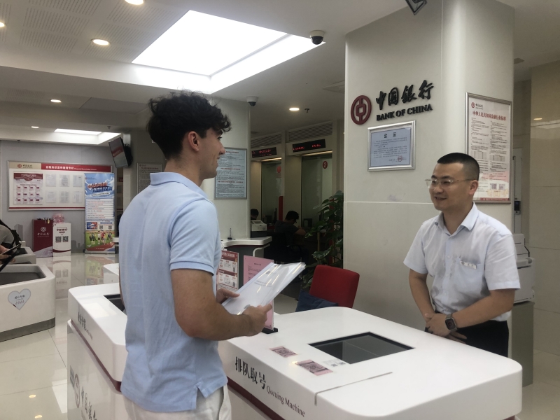 中国银行武汉珞珈山支行网点工作人员为外籍留学生提供服务。