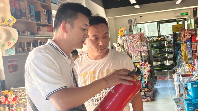 客户经理（左）与客户一起检查灭火器
