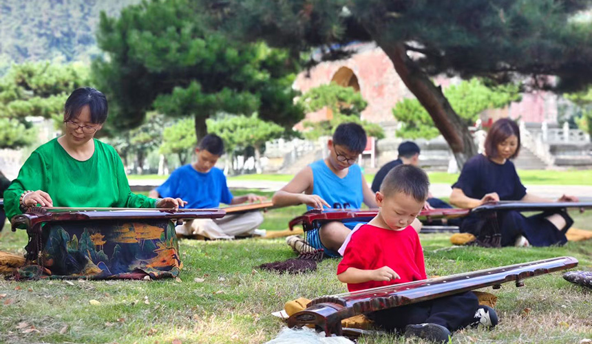 古琴师正带领学生和家长们学习古琴弹奏技巧