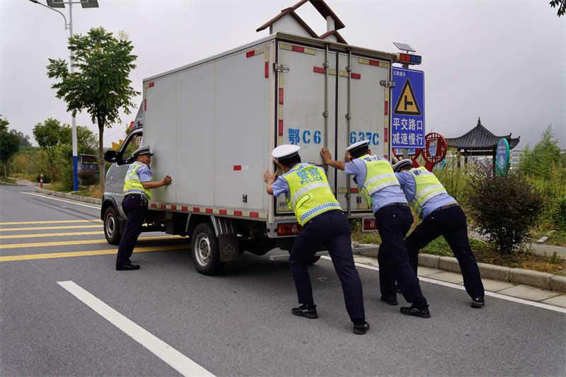 竹溪县公安局交警大队三中队帮助厢式货车处理故障。