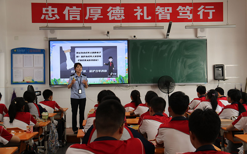 普法人员为学生们讲解电子烟危害。黄雨夕摄