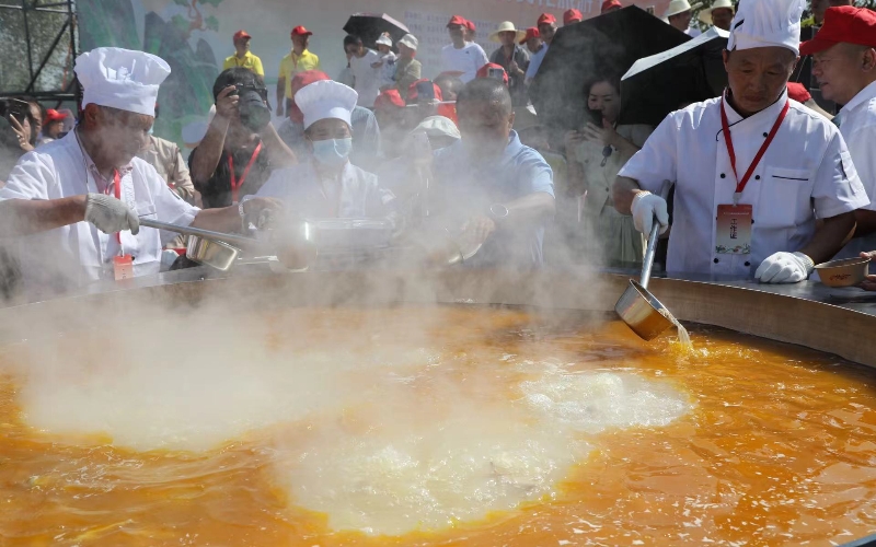 汪集汤食文化旅游节现场一口直径2.3米、冒着热气的大锅徐徐揭开锅盖。