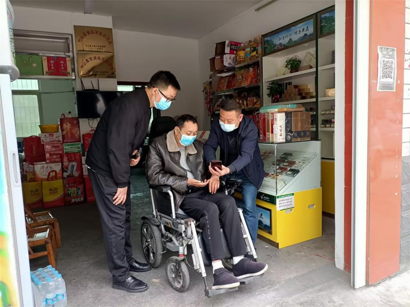 指导困难零售户线上操作签收系统。周迎春摄