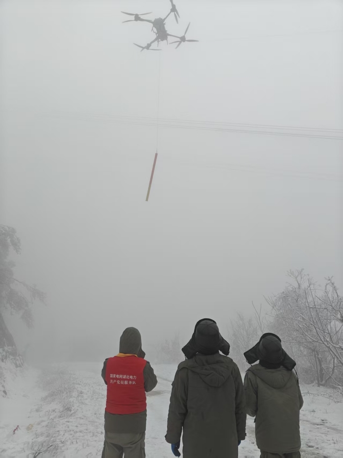 國網湖北送變電公司員工運用重載無人機開展線路除冰作業。