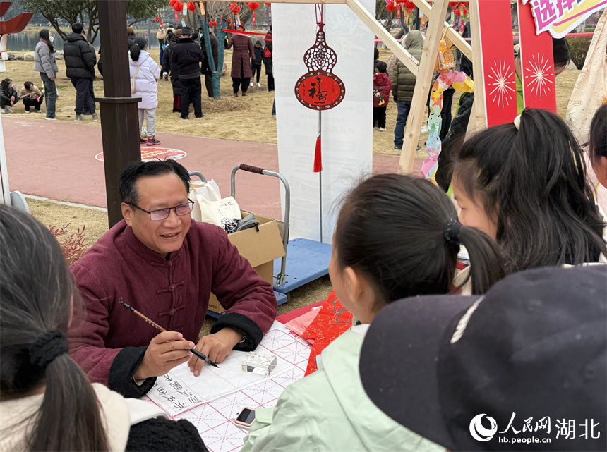 双钩书法摊位围满了学习观看的市民。人民网记者 周恬摄