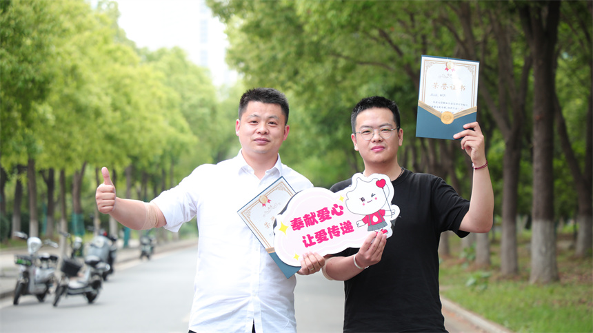 武漢工商學院團委書記邱玉添和愛心學子獻血后合照。芮雨欣攝