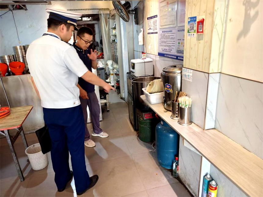 十堰消防监督员正在指导考点周边商户整改火灾隐患。蔡明珠摄