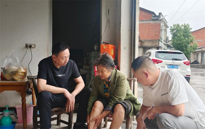 工作人员询问老人左腿伤势恢复情况。