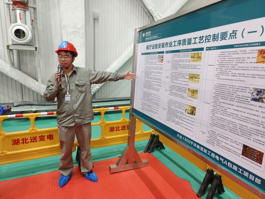 国网湖北电力职工代表向学生介绍阀厅设备。陈嘉慧摄