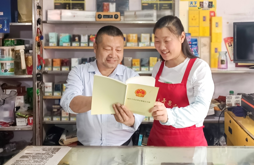 6月6日，襄陽市襄州區煙草專賣局工作人員（左）深入零售商店開展普法宣傳工作。王建兵攝