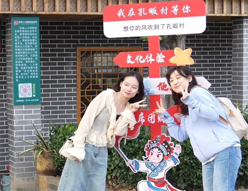 外地游客在打卡牌前拍照。