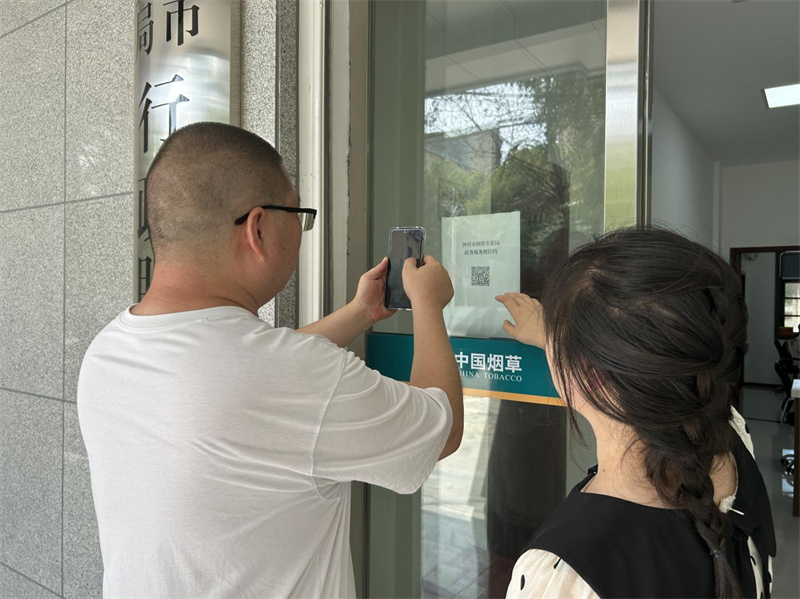 工作人员为前来咨询办证群众介绍“政务服务便民码”。黄杰摄
