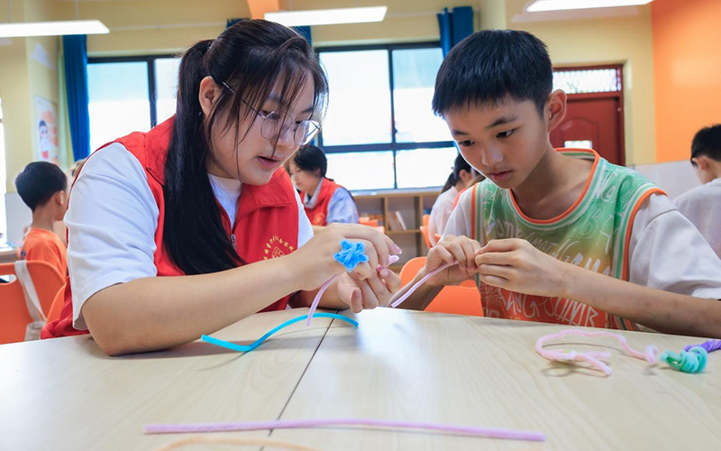 鄖西縣城關鎮王家坪村紅軍小學愛心托管班的孩子在志願者帶領下做手工。鄒景根攝