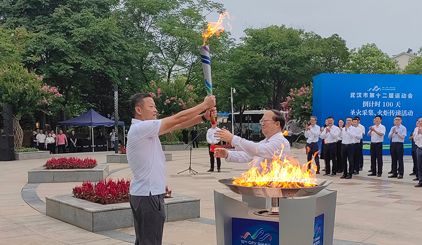 首棒火炬手常衛魏從武漢市委常委、武漢經濟技術開發區工委書記劉子清手中接過聖火。人民網記者 郭婷婷攝