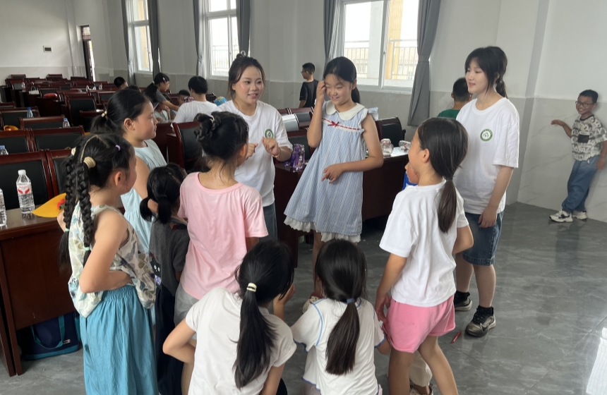 图为志愿者老师课间和小朋友们玩游戏