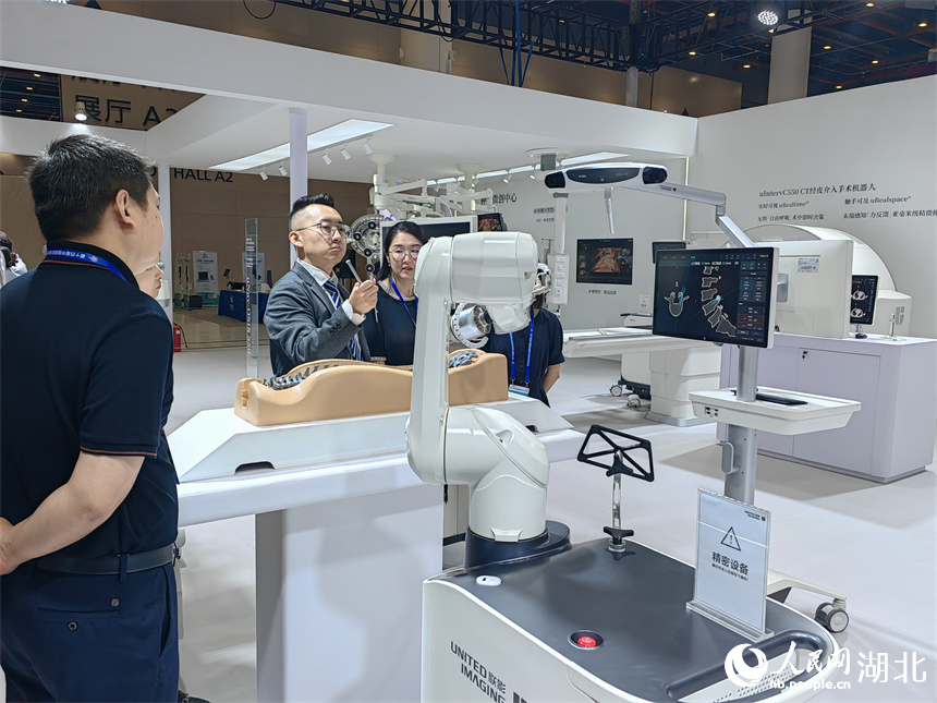 采购商正在观看一体化骨科手术机器人演示如何为脊柱创伤病人手术。人民网记者 郭婷婷摄