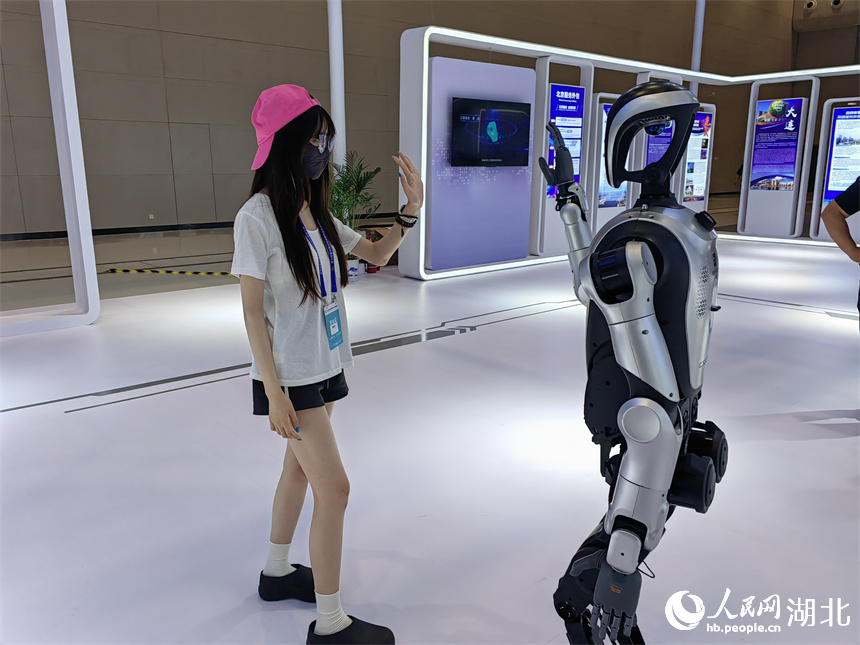 参会者与服务外包企业带来的人形机器人互动。人民网记者 郭婷婷摄