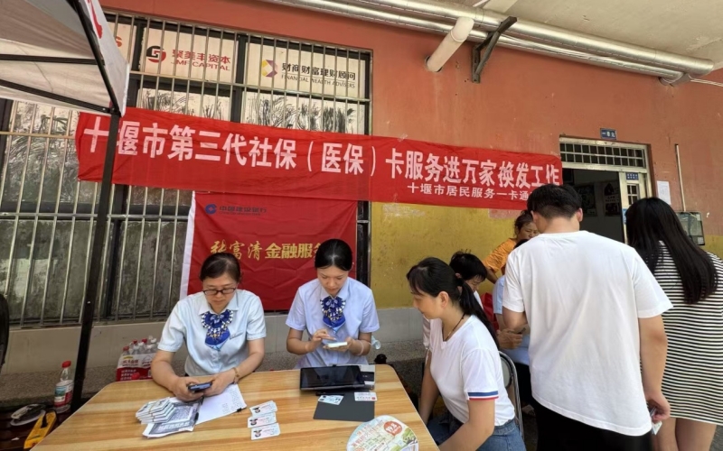 建行湖北十堰分行張富清金融服務隊工作人員冒高溫進社區，為社區居民辦理第三代社保卡換卡業務.