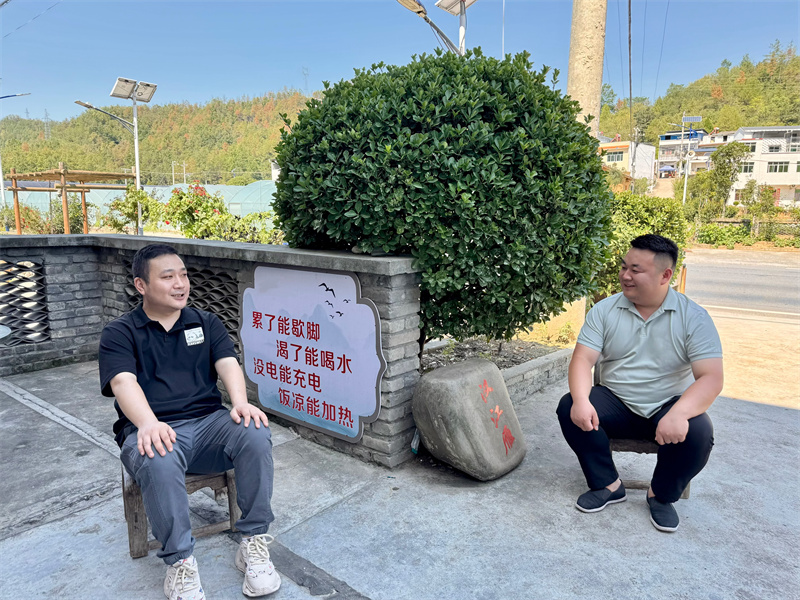 环卫工在店门口歇脚。王云摄