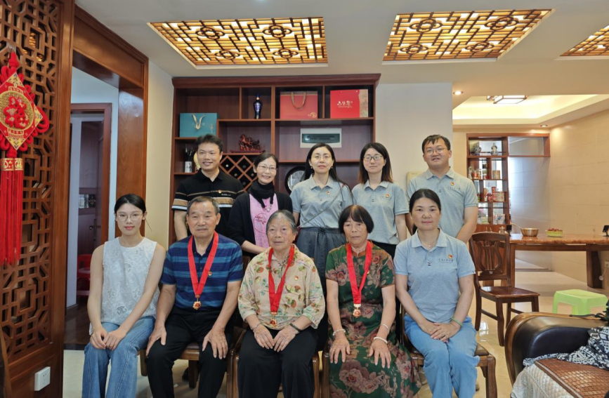 广西家访队伍与三位党龄逾50年的党员合影。学校供图