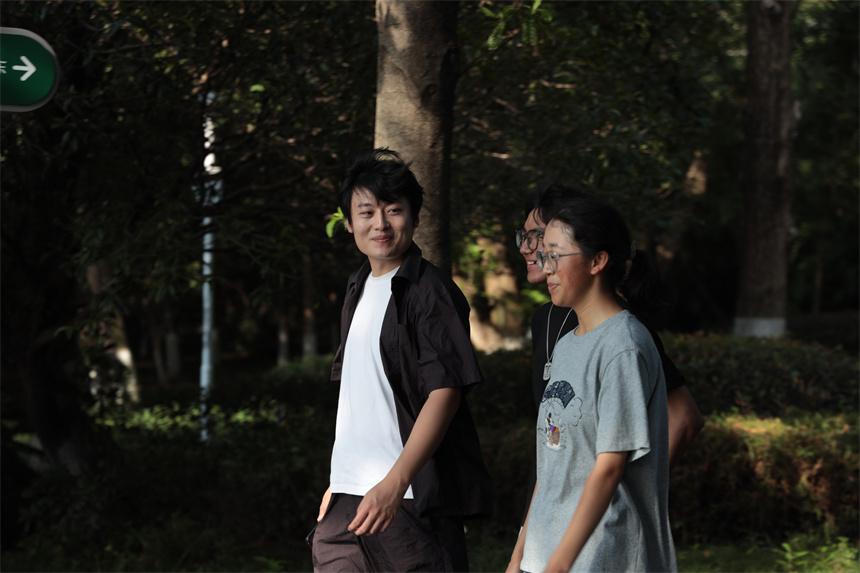 刘相与两位同学漫步校园。学校供图