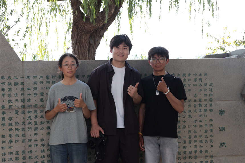 刘相与两位同学在学校南湖边合影。学校供图