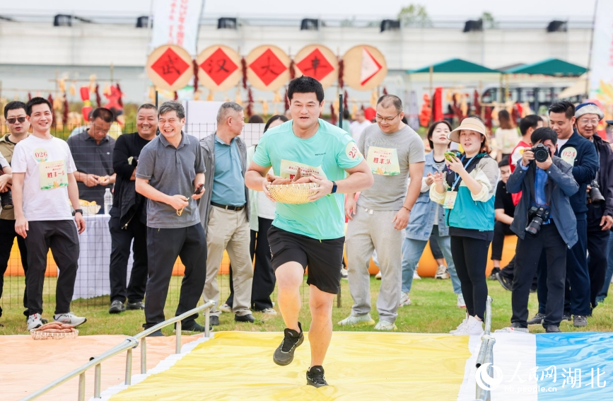 武漢2025中國農民豐收節農趣運動會賽場上，選手們端著紅薯接力奔跑。人民網記者 郭婷婷攝