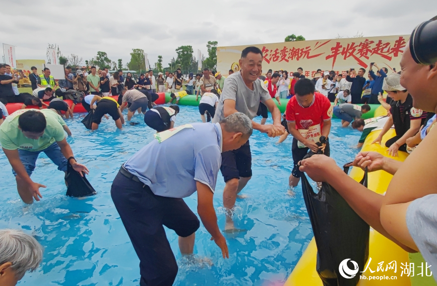 “魚躍豐年”比賽中，選手們徒手摸魚，比拼速度與眼力。人民網記者 郭婷婷攝