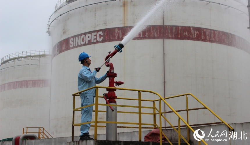 向儲油罐噴射高壓水流。人民網記者 張沛攝
