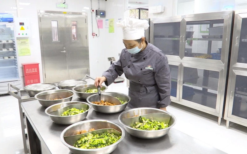 廚師在用溫度計檢查飯菜溫度。人民網記者 郭婷婷攝