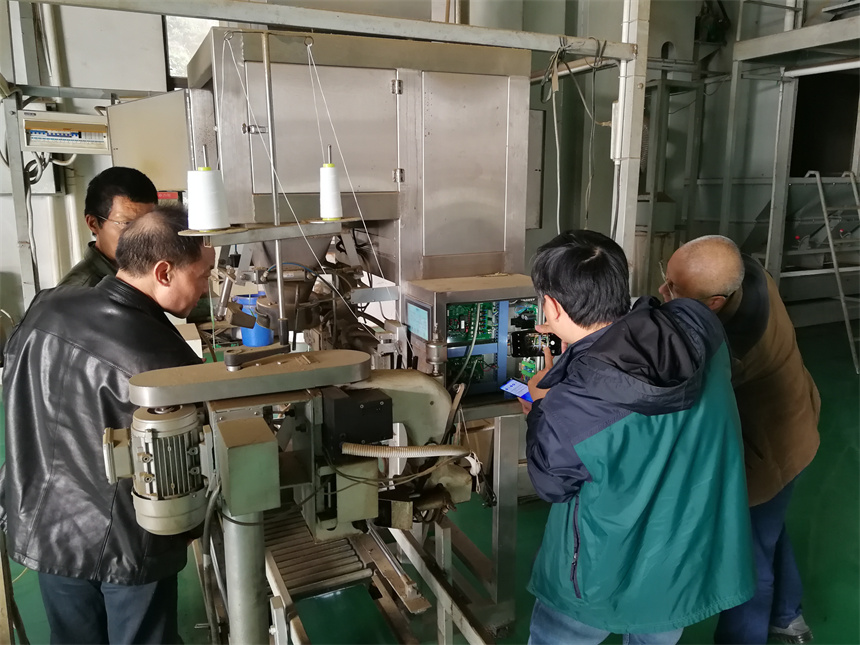 企业工程师与老师一起检测设备状况。学校供图
