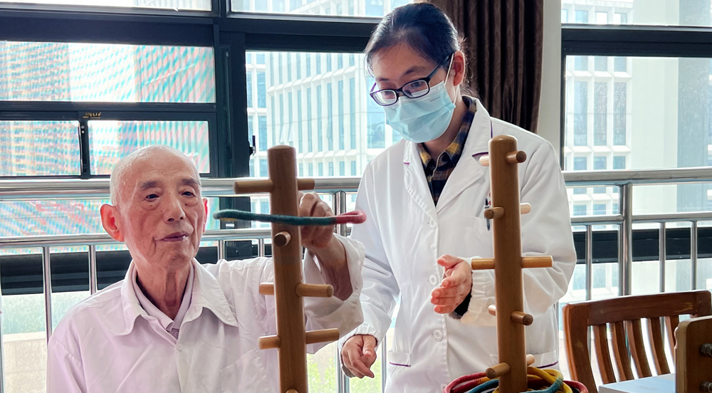  湖北省武漢市社會福利院在院老人在護理員的指導下進行康復訓練。田亞碩 攝


