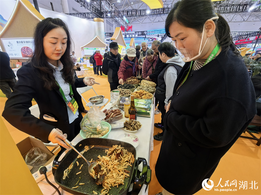 参展商现场烹饪美食，吸引市民品鉴。