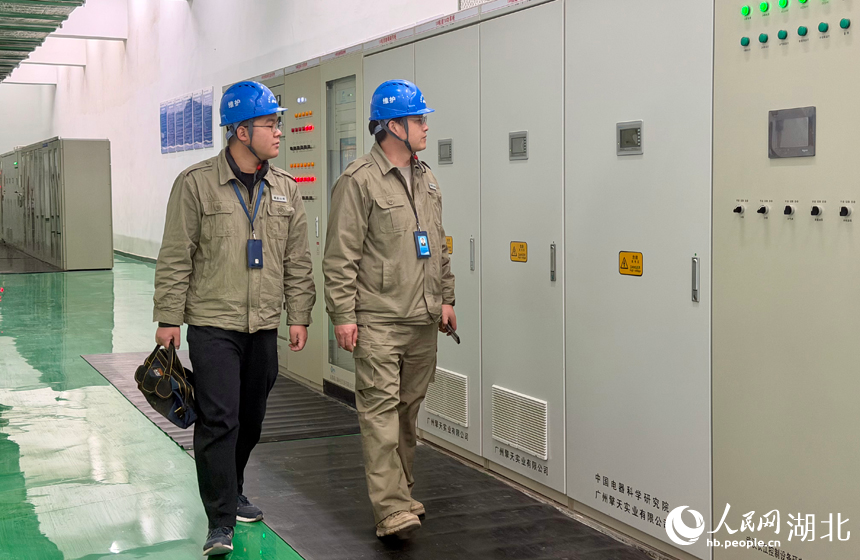 电站工作人员对机柜进行巡检。人民网记者 张沛摄