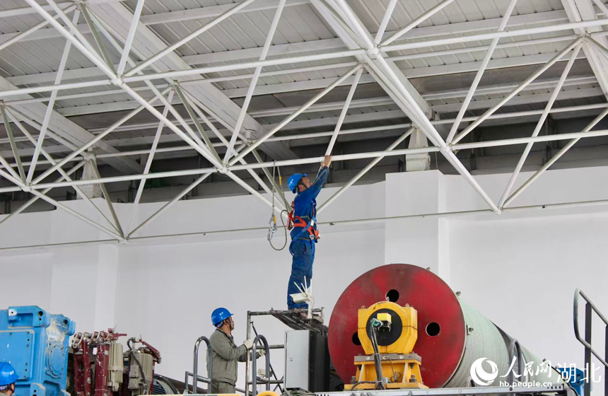 电站工作人员正在进行厂房钢屋架变形观测。人民网记者 王郭骥摄