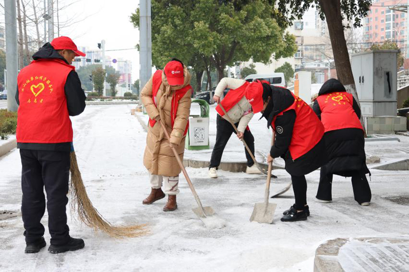“紅帽子”志願服務隊在街頭掃雪除冰。