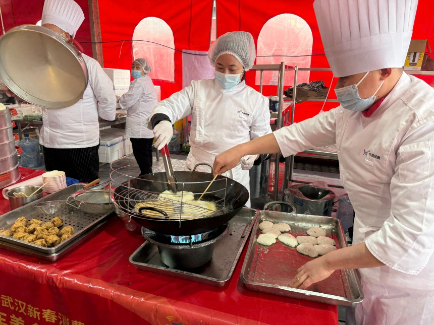 年货市集中，厨师在制作本地美食。