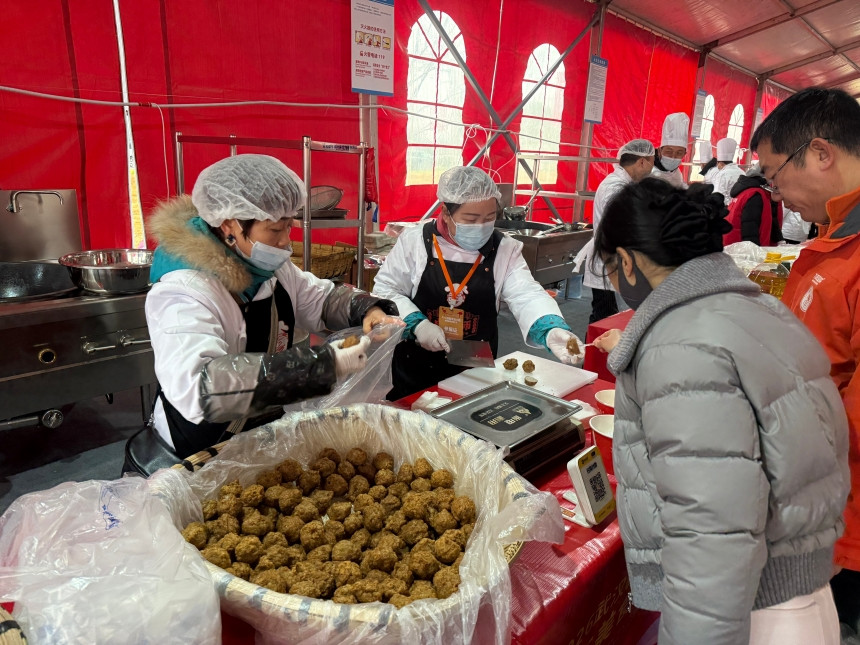 市民在年货市集采购炸丸子、藕汤等特色产品。
