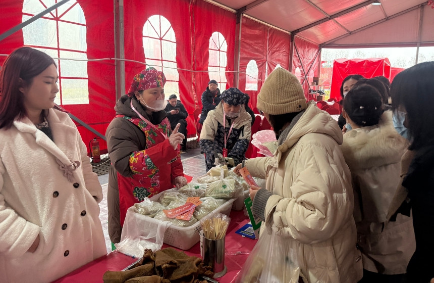 市民在年货市集品尝采购特色食品。