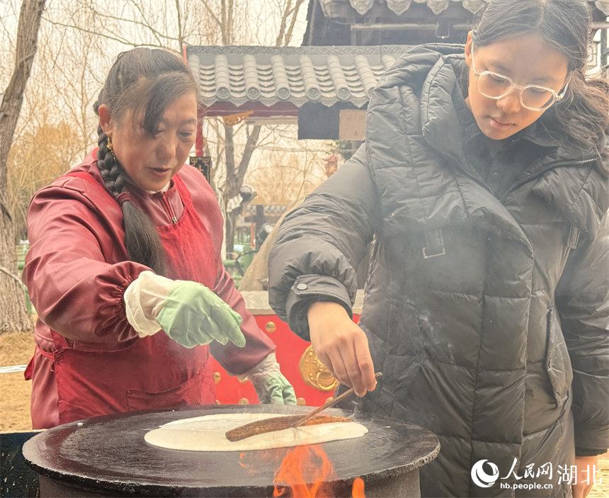 游客体验摊豆丝。