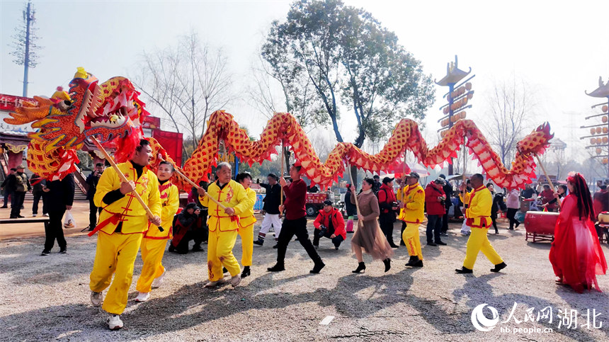 游客体验舞龙表演。
