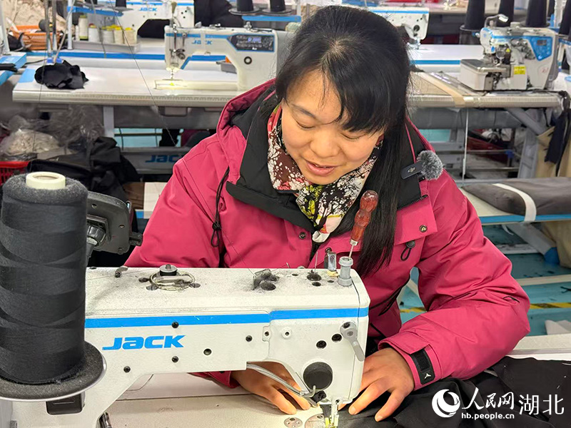 样衣制作师文慧敏一边制作服饰一边与记者交谈。人民网记者 张隽摄