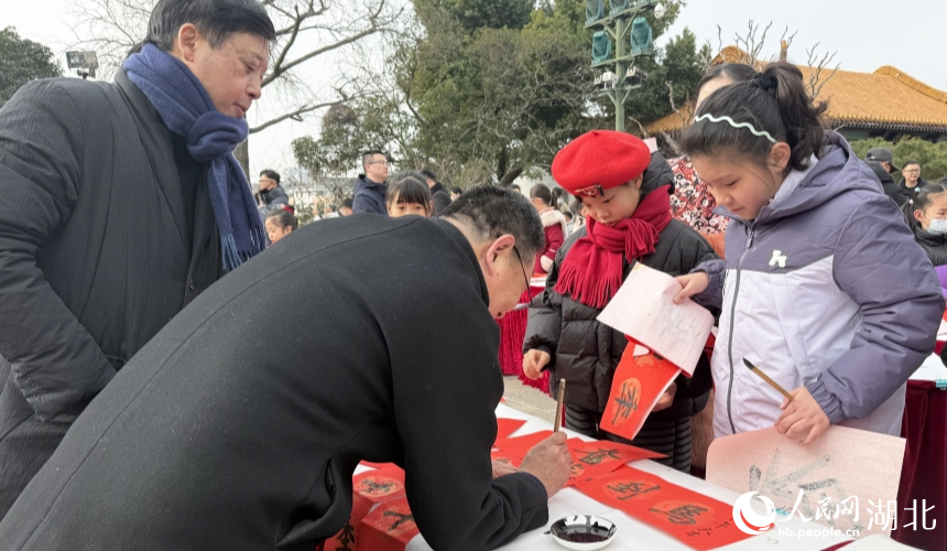 书法家来到小朋友的桌前指导书法。人民网记者 周恬摄