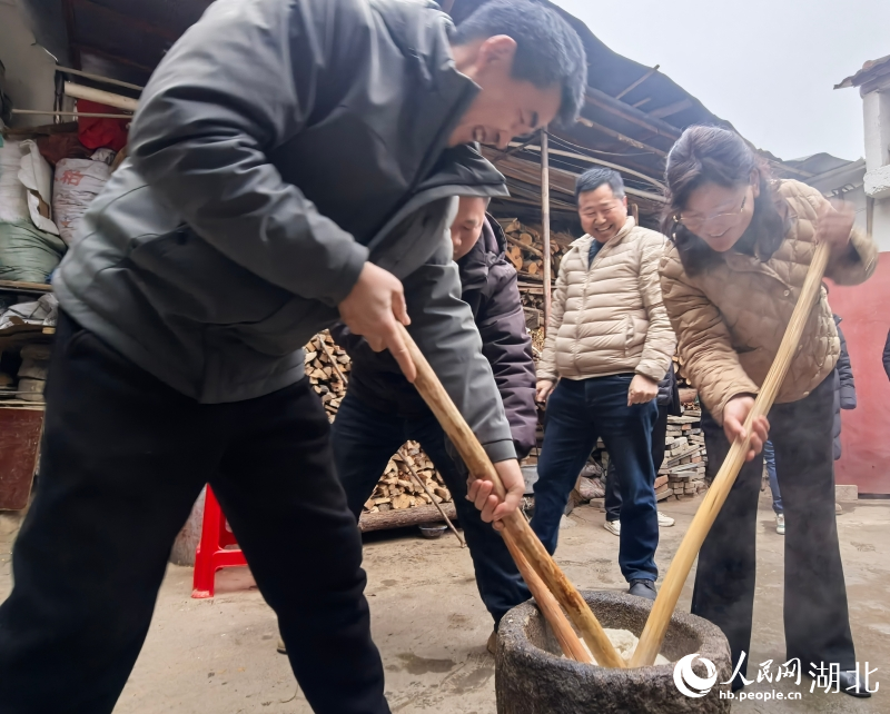 梁云英（右一）正在和村民一起打糍粑。人民网记者 周雯摄